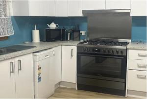 a kitchen with a black stove and a microwave at Shoal Bay Lookout in Kingscote