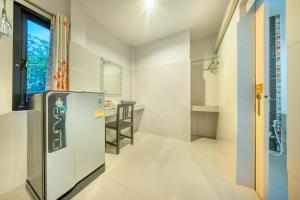 Il comprend une cuisine équipée d'un réfrigérateur et d'une table. dans l'établissement U Resort Nakhon Ratchasima, à Nakhon Ratchasima 51 autres photos