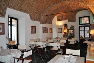 un restaurant avec des tables et des chaises blanches dans une salle dans l'établissement Hotel Residence Baiadelsole, à Laigueglia