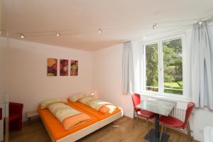 1 dormitorio con cama, mesa y ventana en Chesa Quadrella jedes Zimmer mit Küchenzeile inklusive Bergbahnen im Sommer, en Pontresina