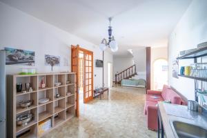 un soggiorno con un divano rosa e una stanza di Retreat dell'Orso - Villa per Vacanze in centro - Frontemare a Torre dell'Orso