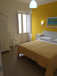 una camera con un grande letto e una parete gialla di Corallo Home a Carovigno