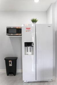 a white refrigerator with a microwave on top of it at River Lane Studio in Riverview