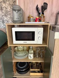 a microwave oven sitting on top of a shelf at Chalet La Savane in Le Gond