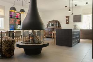a kitchen with a fire place in the middle of a room at Viitina vesiveski in Rõuge