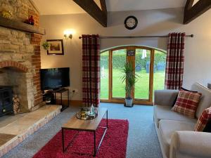a living room with a couch and a fireplace at Rivers Edge Cottage in Shotley Bridge
