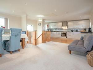 a kitchen and living room with a table and chairs at The White House in Poundstock