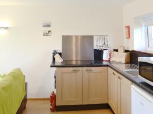 eine Küche mit einer Arbeitsplatte und einem Kochfeld in der Unterkunft Primrose Cottage in Winterborne Steepleton