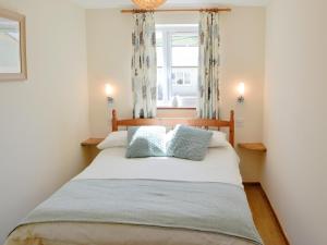 ein Schlafzimmer mit einem großen Bett mit zwei Kissen in der Unterkunft Primrose Cottage in Winterborne Steepleton