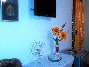 a table with a vase with orange flowers on it at Bed&Breakfast La Cornucopia in Gallipoli