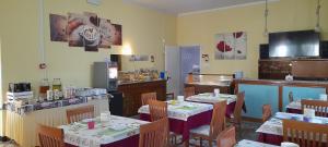 a dining room with tables and chairs in a restaurant at Hotel Carmen Viserba in Rimini