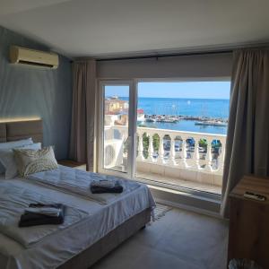 a bedroom with a bed and a large window at Marina Elegance Apartments in Balchik