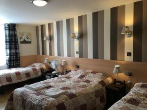 伦敦圣乔治酒店的酒店客房设有两张床和条纹墙 更多20张照片