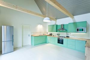 a kitchen with green cabinets and a refrigerator at Irota EcoLodge in Irota