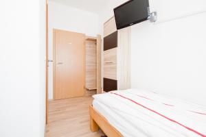 a bedroom with a bed and a tv on the wall at Gästehaus Neckarsulm in Neckarsulm