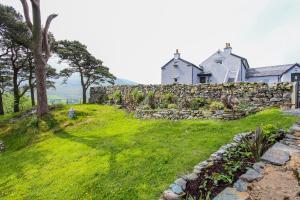 a house on a hill with a stone wall at Gorse Hill Farm in Newcastle