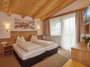 a hotel room with two beds and a window at Appartement Gästehaus Bergkristall in Sölden