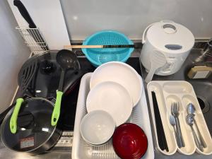 a kitchen counter with dishes and utensils in a sink at Comfort CUBE PHOENIX Yakuin in Susakiuramachi