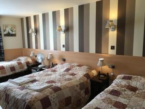 um quarto de hotel com duas camas e um espelho em St George Hotel em Londres