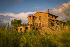 an old stone house sitting on top of a field at Casas Rurales Lalo y Chelo in La Aldehuela