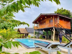 a tree house with a pool and a man walking towards it at Sigiriya Elegant Resort in Sigiriya