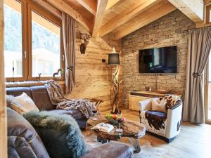 a living room with two couches and a tv at Chalet Leßner - Pure design & tranquility in Leutasch
