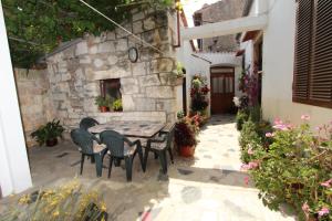 un patio con mesa y sillas frente a un edificio en Apartment Riki, en Rovinj