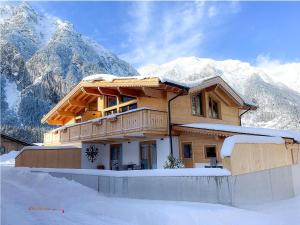 a house in the snow in front of mountains at Chalet Leßner - Pure design & tranquility in Leutasch