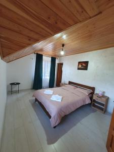 a bedroom with a large bed and a wooden ceiling at Cabana belvedere (VIS) in Colibiţa