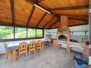 a dining room with a brick fireplace and a table and chairs at Cabana belvedere (VIS) in Colibiţa