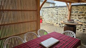 a table and chairs on a patio with a table at Les Forsythias in Messeix