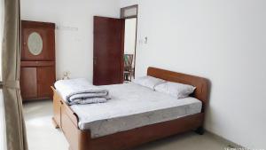 a small bedroom with a bed with towels on it at Modern Minimalist House Semarang in Stasiun Tawang