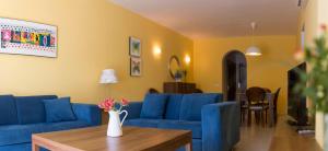 una sala de estar con sofás azules y una mesa. en Mena Plaza, en Nerja