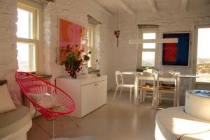 a living room with red chairs and a table at The Art House in Vourkari