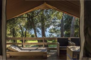 einen Pavillon mit 2 Stühlen und einem Tisch in der Unterkunft Easyatent FKK Safari tent Koversada Naturist - clothes free in Vrsar