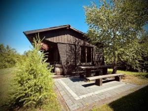 a wooden cabin with a bench in a yard at Zielone Roztocze in Susiec