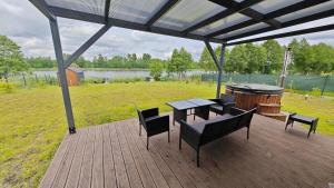 a deck with a table and chairs and a grill at Kozacki Domek in Lubowiec