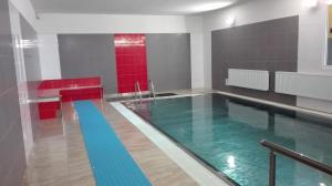 a swimming pool in a room with red and blue at Hotel Prom in Svoboda nad Úpou