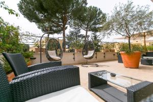 eine Terrasse mit Stühlen, einem Tisch und Spiegeln in der Unterkunft Best Western Hotel Rivoli in Rom