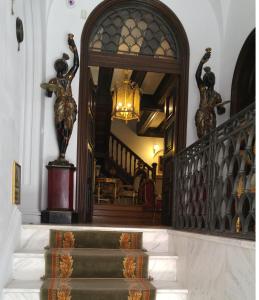 a hallway with a staircase with a statue of two women at Scala Boutique-Hotel in Bucharest