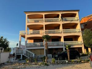 an apartment building with balconies and a car parked in front at Apartments Bernarda 2 in Nin