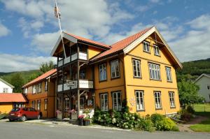 a yellow building with a flag on top of it at Fyresdal Bed and Breakfast in Moland