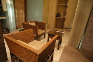 a room with wicker chairs and a table and a kitchen at Hotel Galaxy Inn !! 5 Min From Nemcare Hospital !! in Guwahati +27 photos