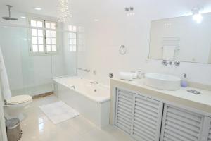 a white bathroom with a sink and a toilet at Villa Franca in Rio de Janeiro