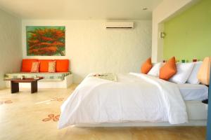 1 dormitorio con 1 cama y una pintura en la pared en Vacation Village Phra Nang Lanta - SHA Extra Plus en Ko Lanta