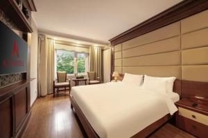 a bedroom with a large white bed and a table at A25 Premium Hotel - 23 Quán Thánh in Hanoi +35 photos