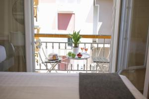 a bedroom with a balcony with a table with fruit on it at KK Athens Fine Stay -Neos Kosmos-Modern Apartments Opposite Metro with Rooftop Lounge & Acropolis Views in Athens