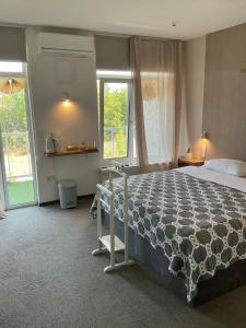 a bedroom with a large bed and a window at Гостевой дом SUN TAG in Chornomors'ke +180 photos