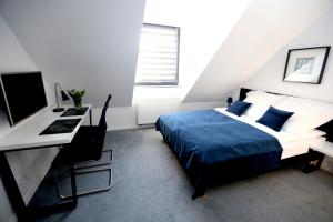 1 dormitorio con 1 cama y escritorio con ordenador en Pure Apartments Kraków, en Cracovia