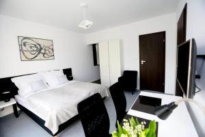 1 dormitorio con 1 cama, escritorio y sillas en Pure Apartments Kraków, en Cracovia